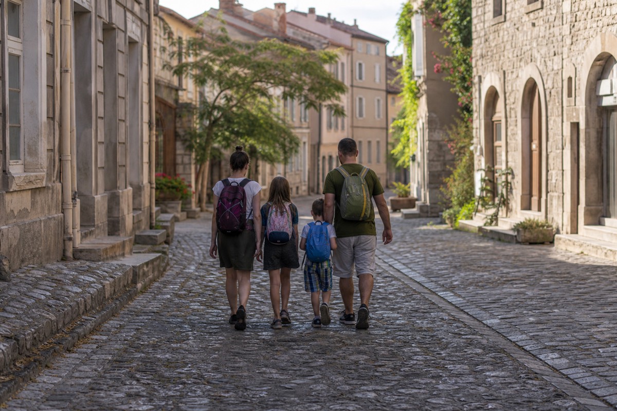 A family walking together along a cobbled European street in the early morning