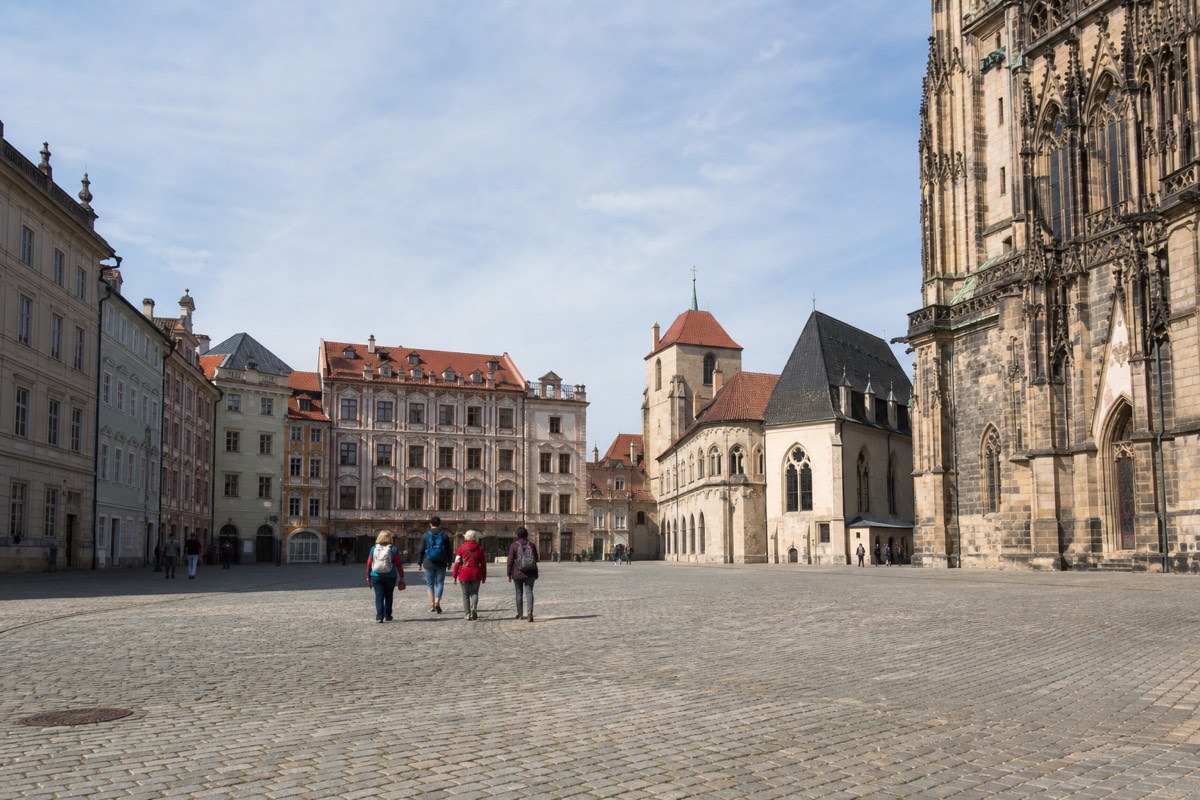 A small tour group crossing a European city square together in the morning